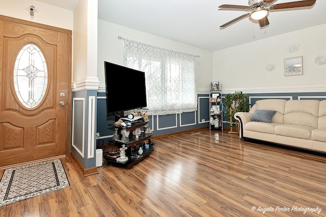 living room with ceiling fan, decorative columns, and wood finished floors