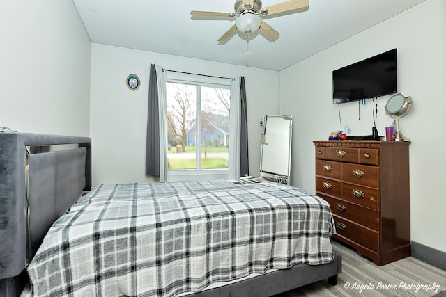 bedroom with baseboards, light wood finished floors, and a ceiling fan
