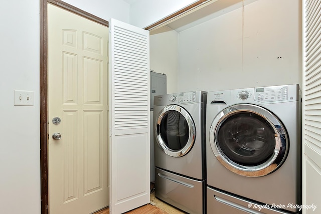 washroom with laundry area, separate washer and dryer, and light wood-type flooring