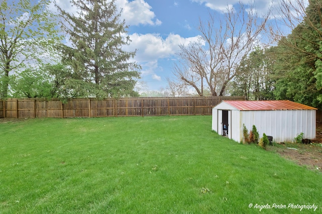 view of yard with a storage unit, fence, and an outdoor structure