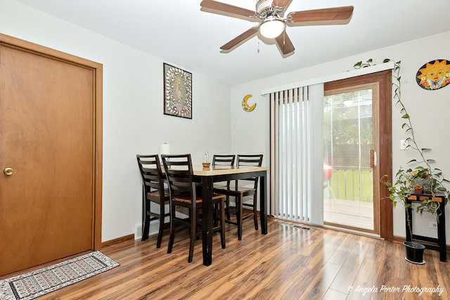 dining area featuring baseboards, visible vents, ceiling fan, and wood finished floors