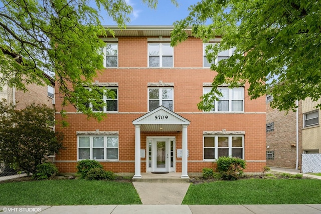 view of front of house with brick siding and a front lawn