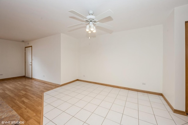 spare room with a ceiling fan, baseboards, and light wood-style flooring