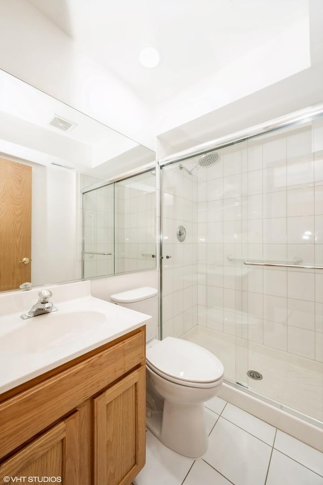 full bath with tile patterned flooring, a shower stall, toilet, and vanity