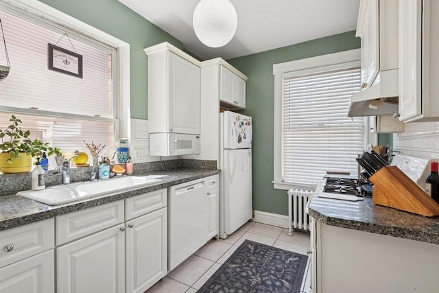 kitchen featuring a sink, white cabinetry, radiator heating unit, and white appliances