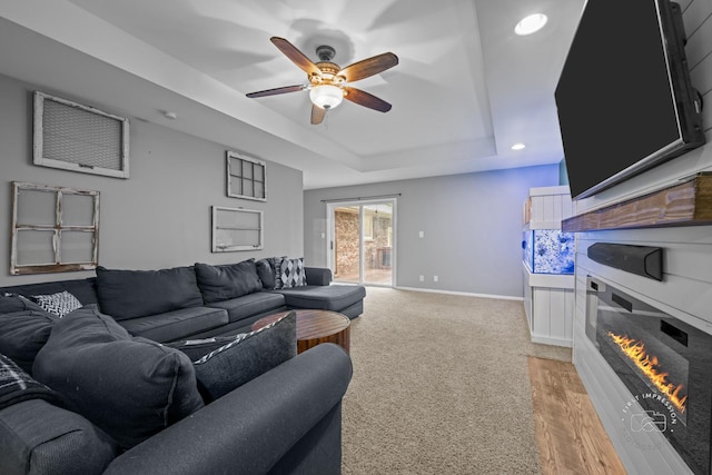 17 S Cypress Dr, Bristol, IL 60512 - living area featuring ceiling fan, a tray ceiling, baseboards, light carpet, and a glass covered fireplace