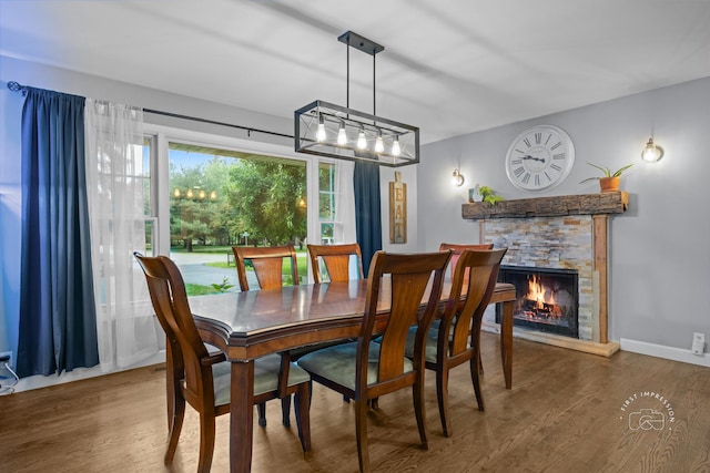 17 S Cypress Dr, Bristol, IL 60512 - dining space featuring wood finished floors, a stone fireplace, baseboards, and a chandelier