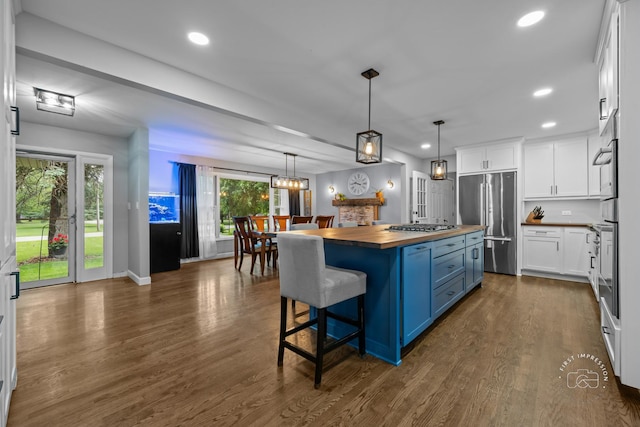 17 S Cypress Dr, Bristol, IL 60512 - kitchen featuring wooden counters, stainless steel appliances, blue cabinetry, white cabinetry, and a kitchen island