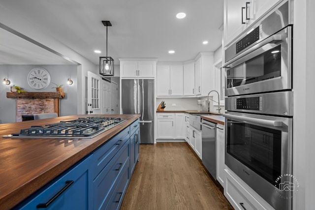 17 S Cypress Dr, Bristol, IL 60512 - kitchen with butcher block countertops, blue cabinets, stainless steel appliances, a sink, and dark wood-type flooring