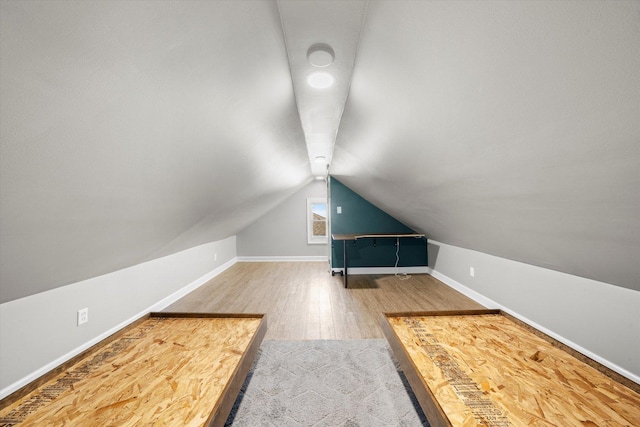 additional living space featuring lofted ceiling, baseboards, and wood finished floors