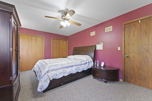 carpeted bedroom featuring two closets and ceiling fan