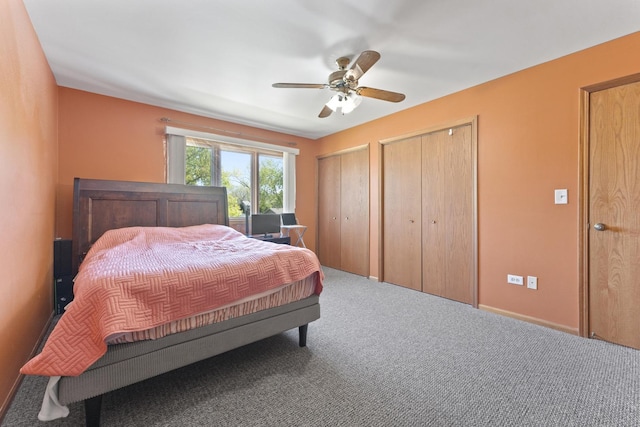 carpeted bedroom with multiple closets and a ceiling fan