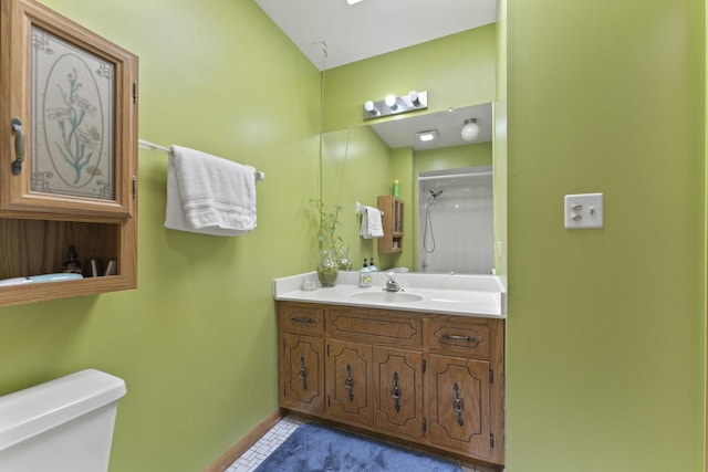 bathroom featuring a shower, toilet, vanity, tile patterned floors, and baseboards