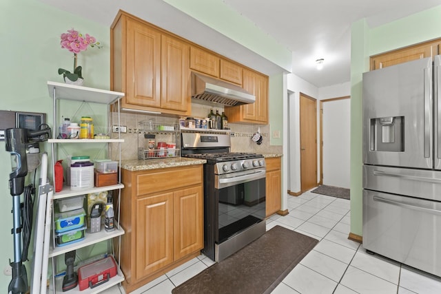 kitchen with appliances with stainless steel finishes, under cabinet range hood, decorative backsplash, and light tile patterned flooring