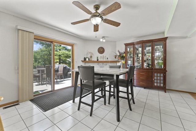 dining area with baseboards, ceiling fan, and light tile patterned flooring