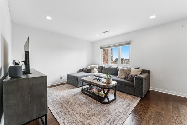 living room with dark wood-style flooring, baseboards, visible vents, and recessed lighting