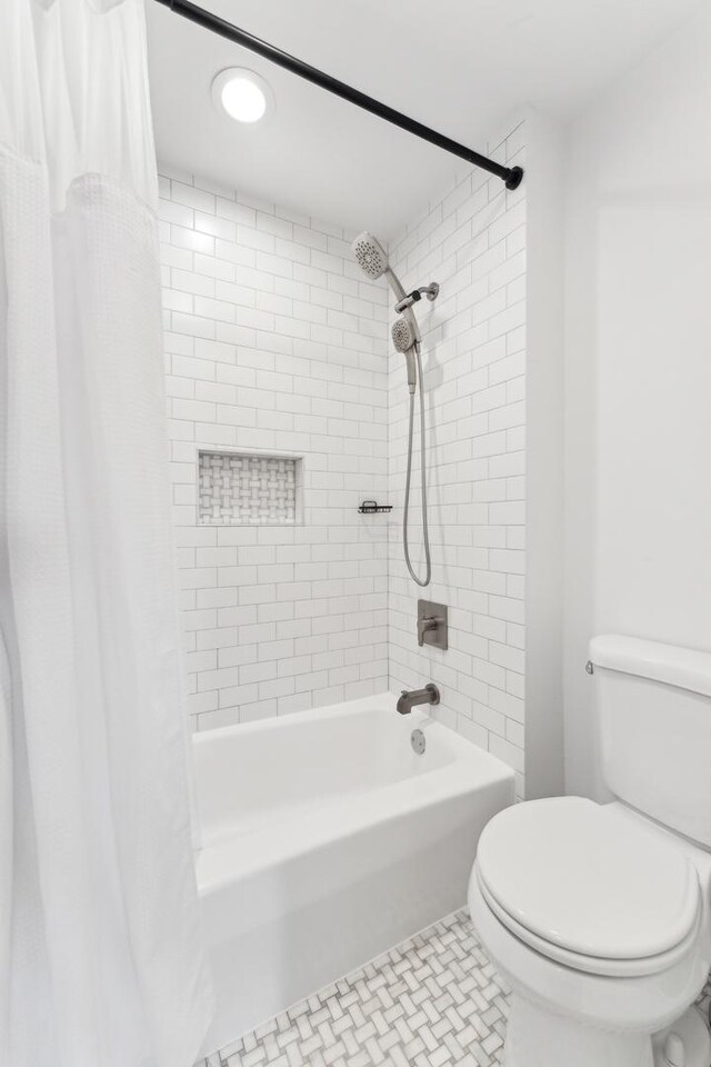 full bathroom featuring toilet, tile patterned floors, and shower / tub combo