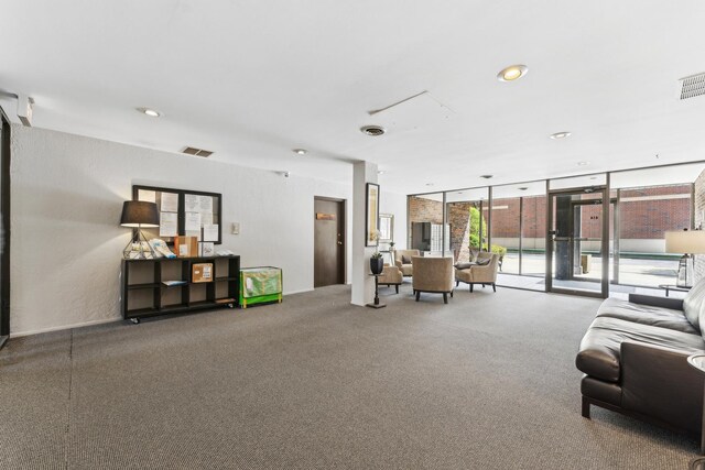 carpeted living area with recessed lighting, visible vents, and a wall of windows