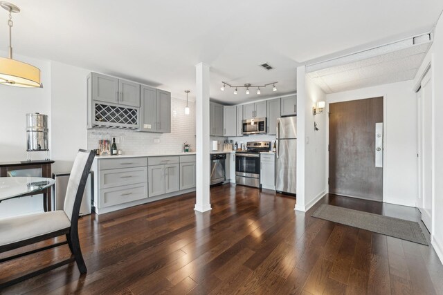 kitchen with stainless steel appliances, gray cabinetry, visible vents, and dark wood-type flooring