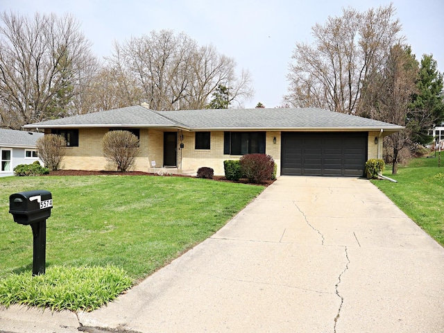 ranch-style home featuring concrete driveway, brick siding, a front yard, and a garage