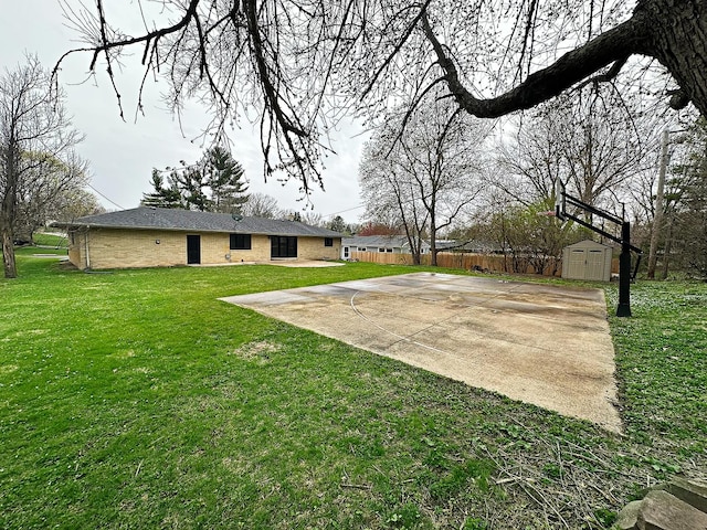 view of yard featuring fence, an outdoor structure, and a storage shed