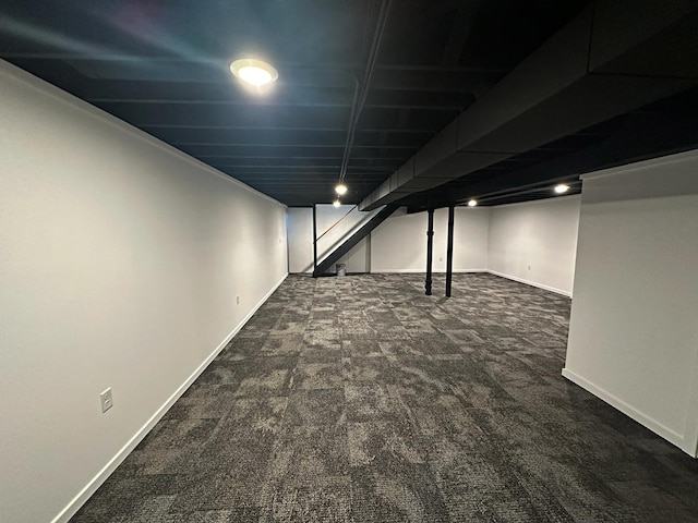 finished basement featuring carpet floors, stairs, and baseboards