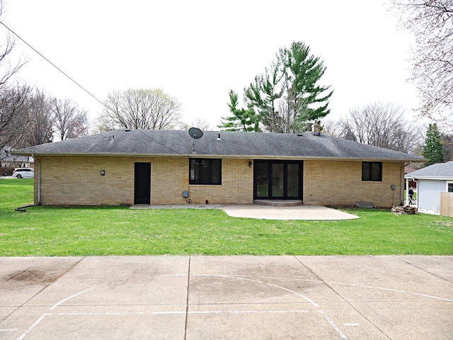 back of property with brick siding, a yard, and a patio area