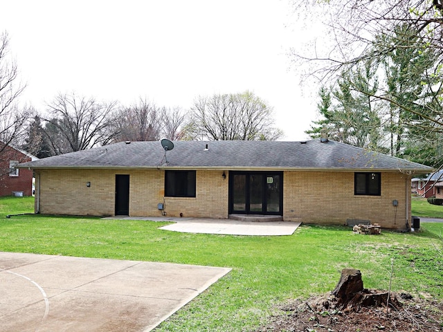 rear view of house featuring brick siding, a yard, and a patio area