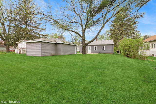 view of grassy yard featuring an outbuilding