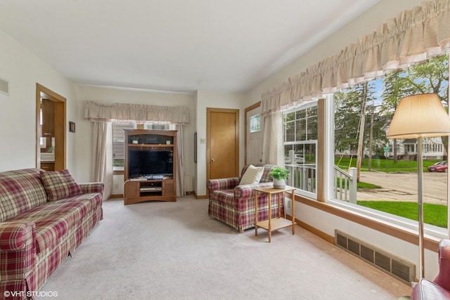 living area with light carpet and baseboards