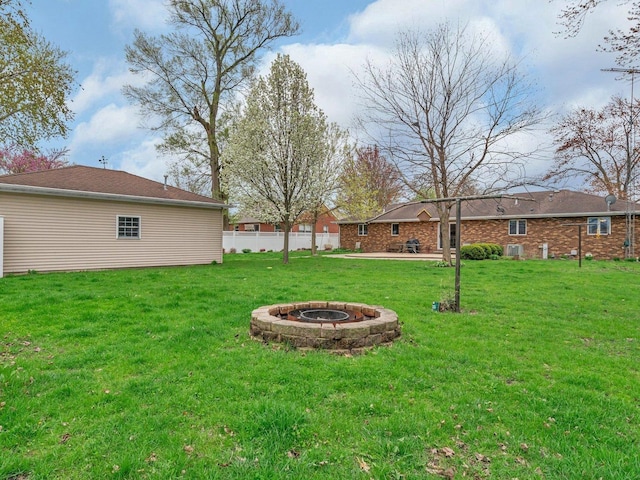 view of yard with a fire pit, a patio area, and fence