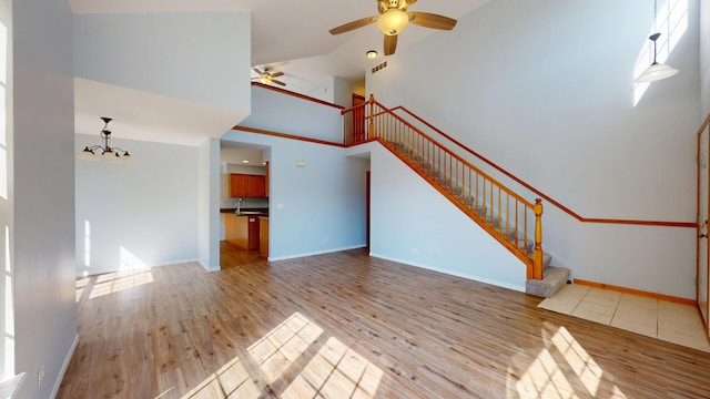 341 Capitol Dr Unit D, Sugar Grove, IL 60554 - unfurnished living room featuring ceiling fan, stairway, wood finished floors, and high vaulted ceiling