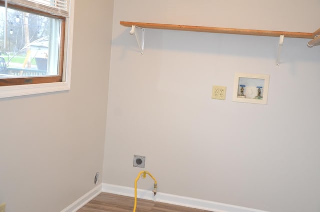 clothes washing area featuring baseboards, laundry area, wood finished floors, electric dryer hookup, and hookup for a washing machine