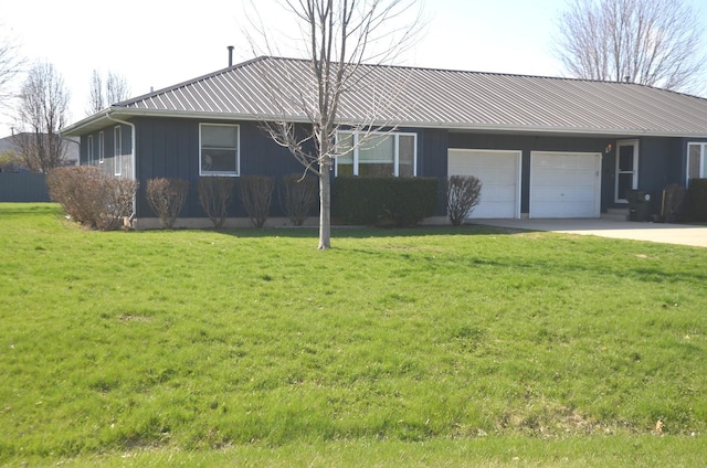 ranch-style house with a front lawn, metal roof, a garage, and concrete driveway