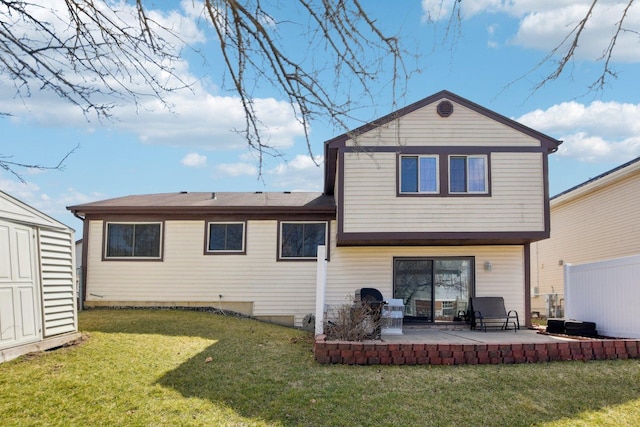 back of house featuring a yard, an outdoor structure, a patio area, and a storage unit