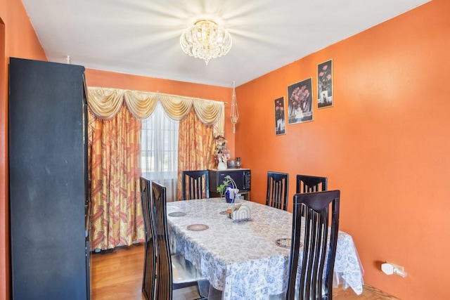 dining room with wood finished floors and a chandelier