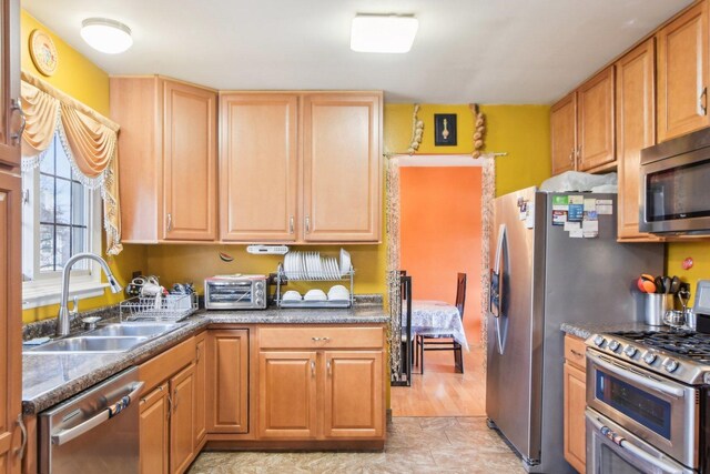 kitchen featuring stainless steel appliances, a toaster, and a sink