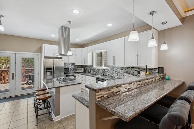 6029 N Ridge Ave, Chicago, IL 60660 - kitchen with stainless steel appliances, island exhaust hood, a kitchen bar, backsplash, and recessed lighting