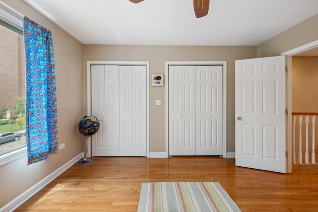 6029 N Ridge Ave, Chicago, IL 60660 - unfurnished bedroom with multiple closets, light wood finished floors, baseboards, and a ceiling fan