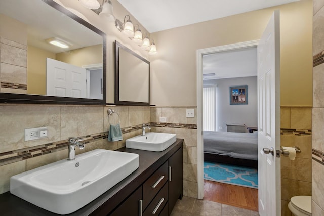 6029 N Ridge Ave, Chicago, IL 60660 - bathroom with tile walls, double vanity, toilet, tile patterned floors, and connected bathroom