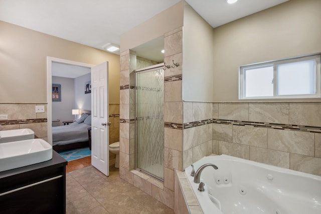 6029 N Ridge Ave, Chicago, IL 60660 - full bathroom with a whirlpool tub, a stall shower, tile walls, double vanity, and ensuite bathroom