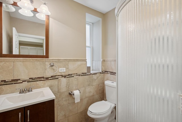 6029 N Ridge Ave, Chicago, IL 60660 - bathroom with toilet, tile walls, vanity, and a wainscoted wall