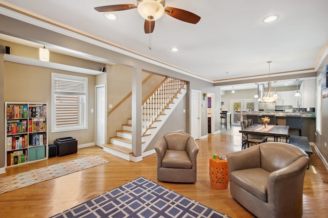 6029 N Ridge Ave, Chicago, IL 60660 - living room with baseboards, light wood-type flooring, stairs, a ceiling fan, and crown molding