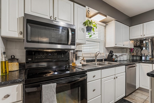 1003 Poplar St, Monticello, IL 61856 - kitchen with stainless steel appliances, a sink, white cabinets, and decorative backsplash
