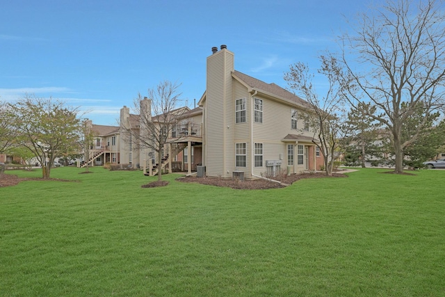 1601 Penny Ln Unit B, Crystal Lake, IL 60014 - rear view of property featuring cooling unit, a lawn, a chimney, and stairway
