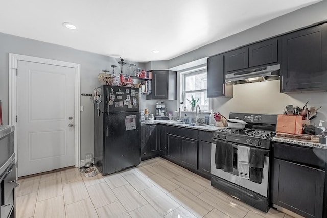 4158 W Nelson St, Chicago, IL 60641 - kitchen featuring under cabinet range hood, dark cabinetry, a sink, freestanding refrigerator, and gas range