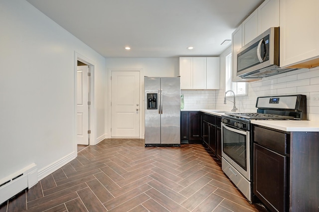4158 W Nelson St, Chicago, IL 60641 - kitchen featuring a sink, tasteful backsplash, baseboard heating, light countertops, and appliances with stainless steel finishes