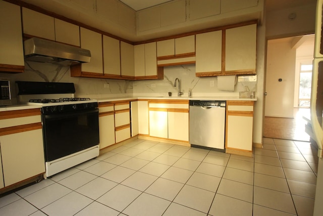 5517 S Dorchester Ave, Chicago, IL 60637 - kitchen featuring under cabinet range hood, stainless steel appliances, a sink, light countertops, and backsplash
