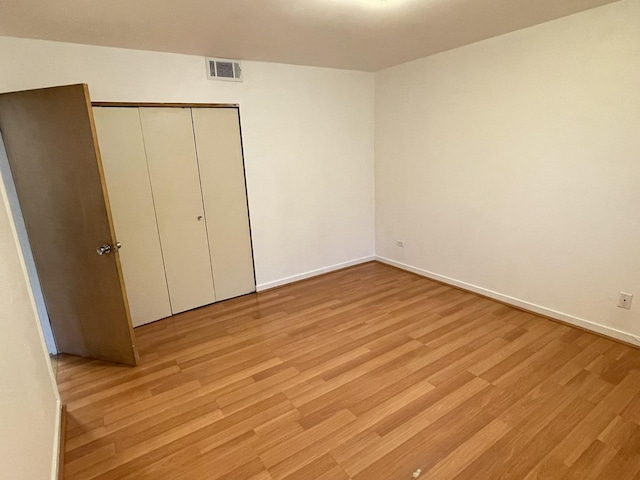 5517 S Dorchester Ave, Chicago, IL 60637 - unfurnished bedroom with light wood-style flooring, baseboards, and a closet