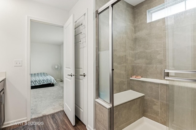 full bathroom featuring vanity, tiled shower, wood finished floors, and ensuite bath